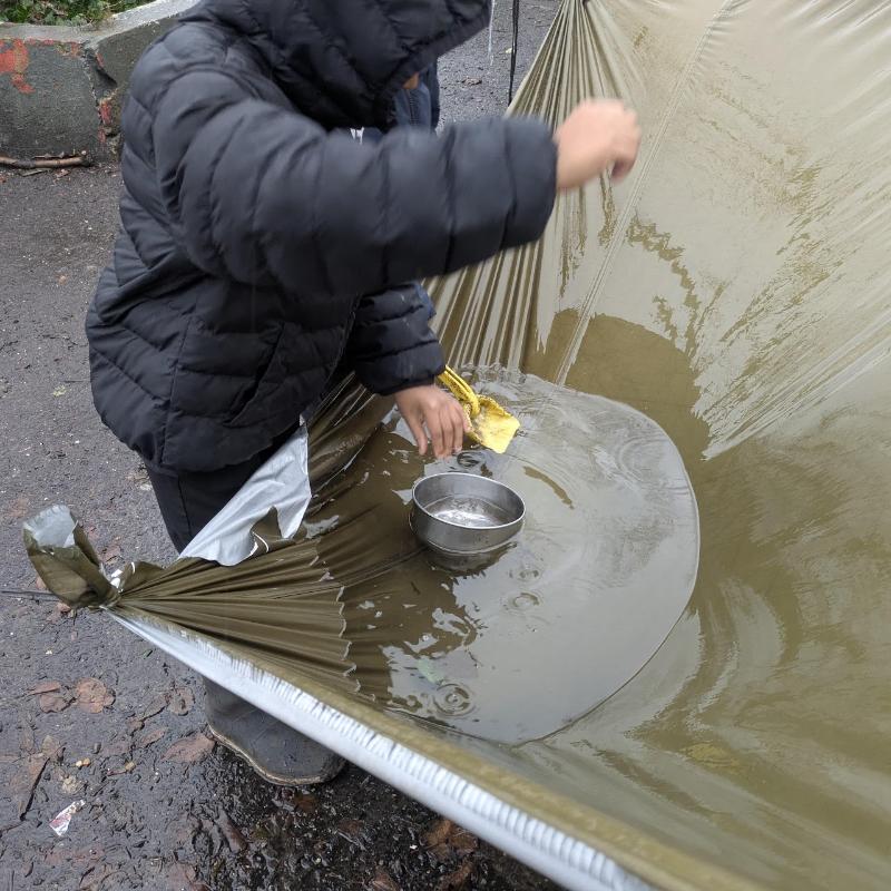 A child working with water and tools on a tarp
