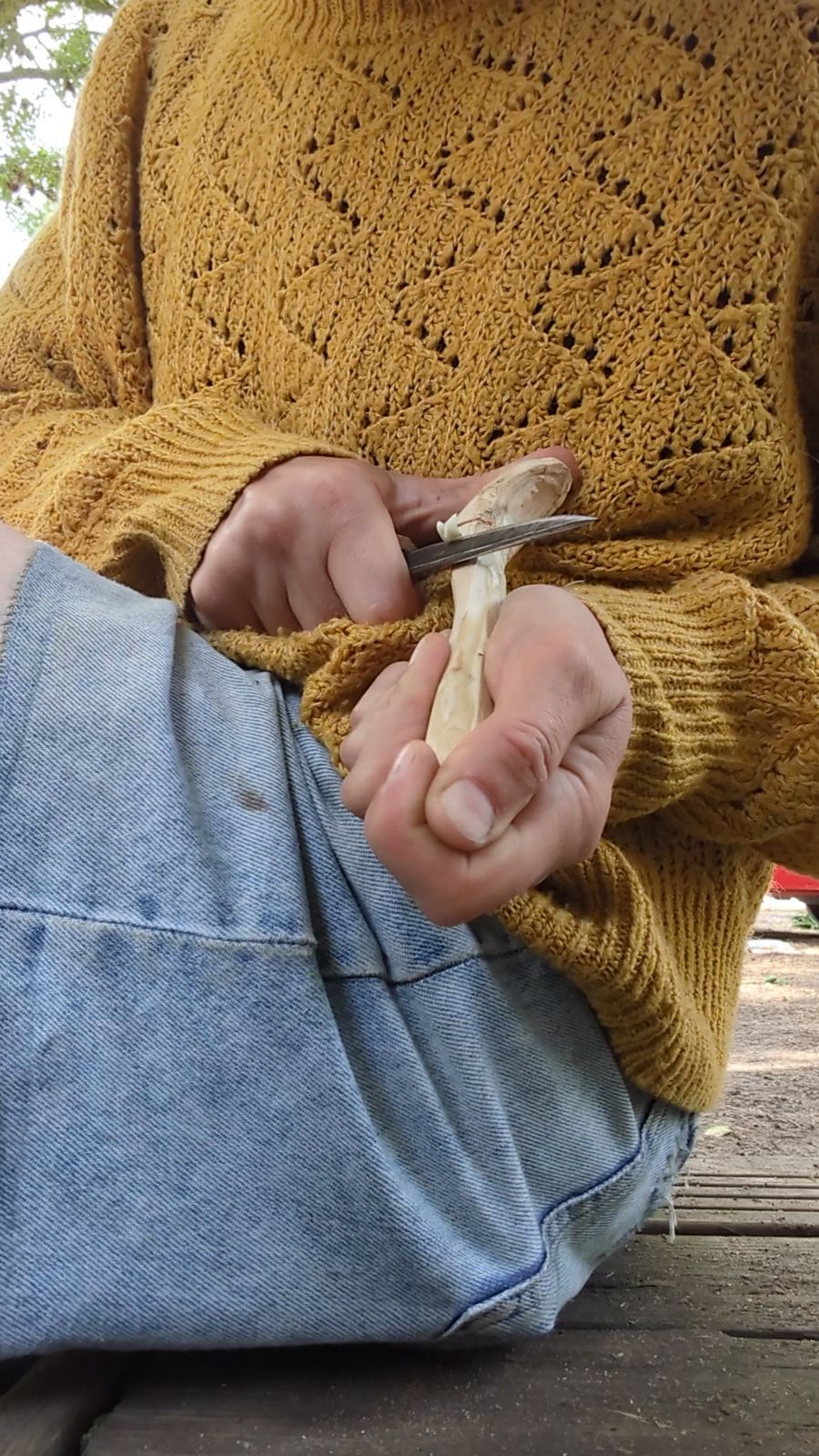 Close-up of hands carving a wooden spoon