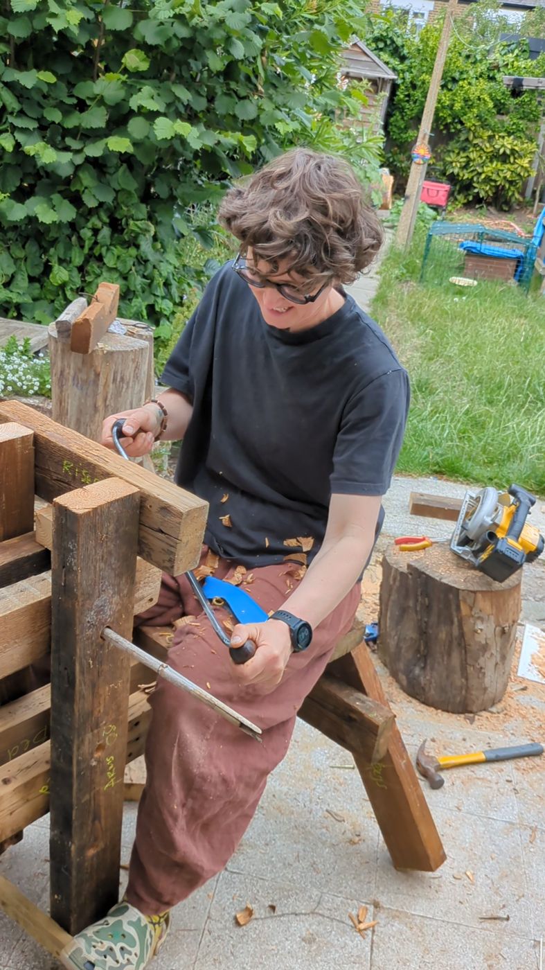 Holly using a drawknife on a shaving horse