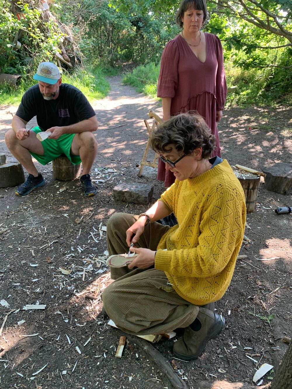 Holly teaching two adults to carve outdoors